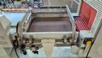 L-shaped packaging sealer with semi-automatic shrink tunnel.